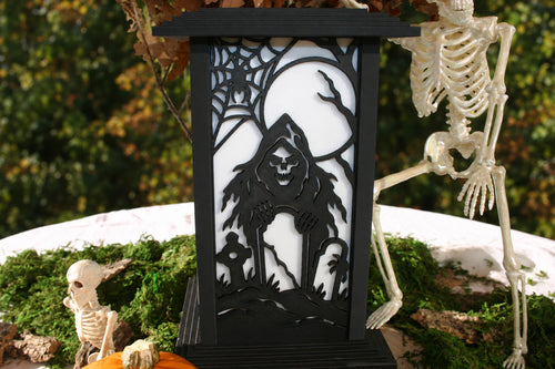 Graveyard Moonrise panel on a Kyoto lamp showing a hooded skeleton, moon, spiderweb and tombstones