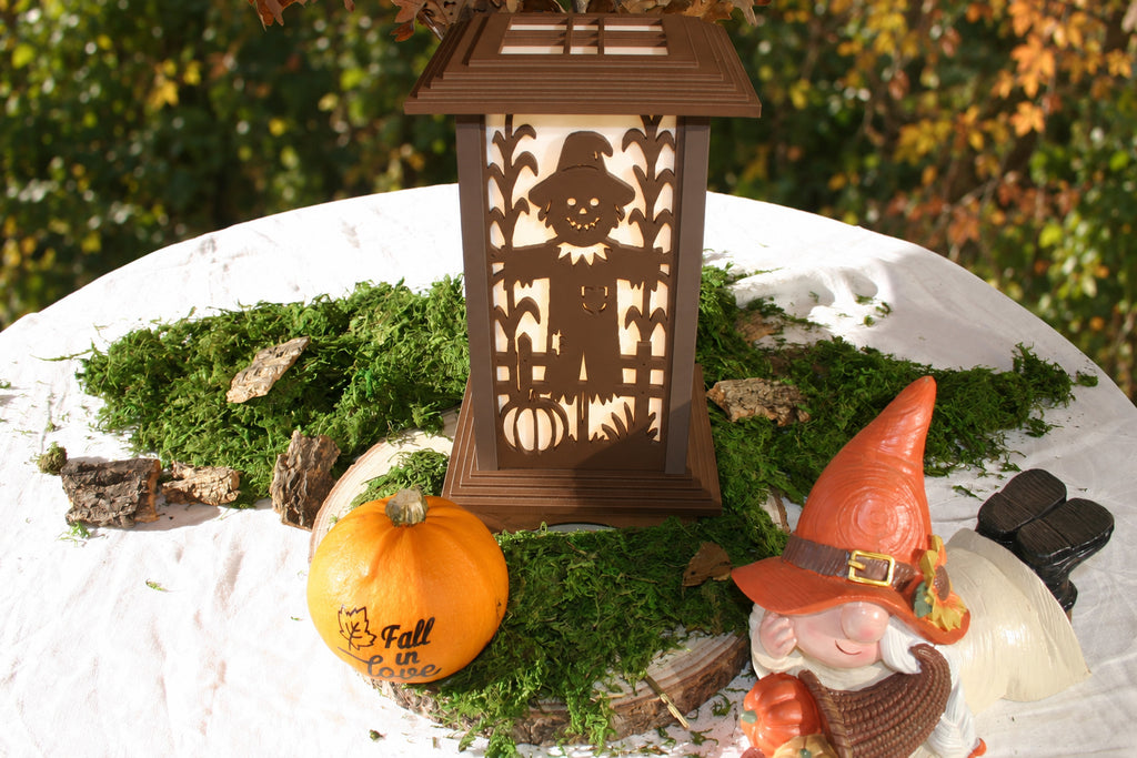 Warmly illuminated Harvest Scarecrow panel on a Kyoto lamp in an autumn tabletop display