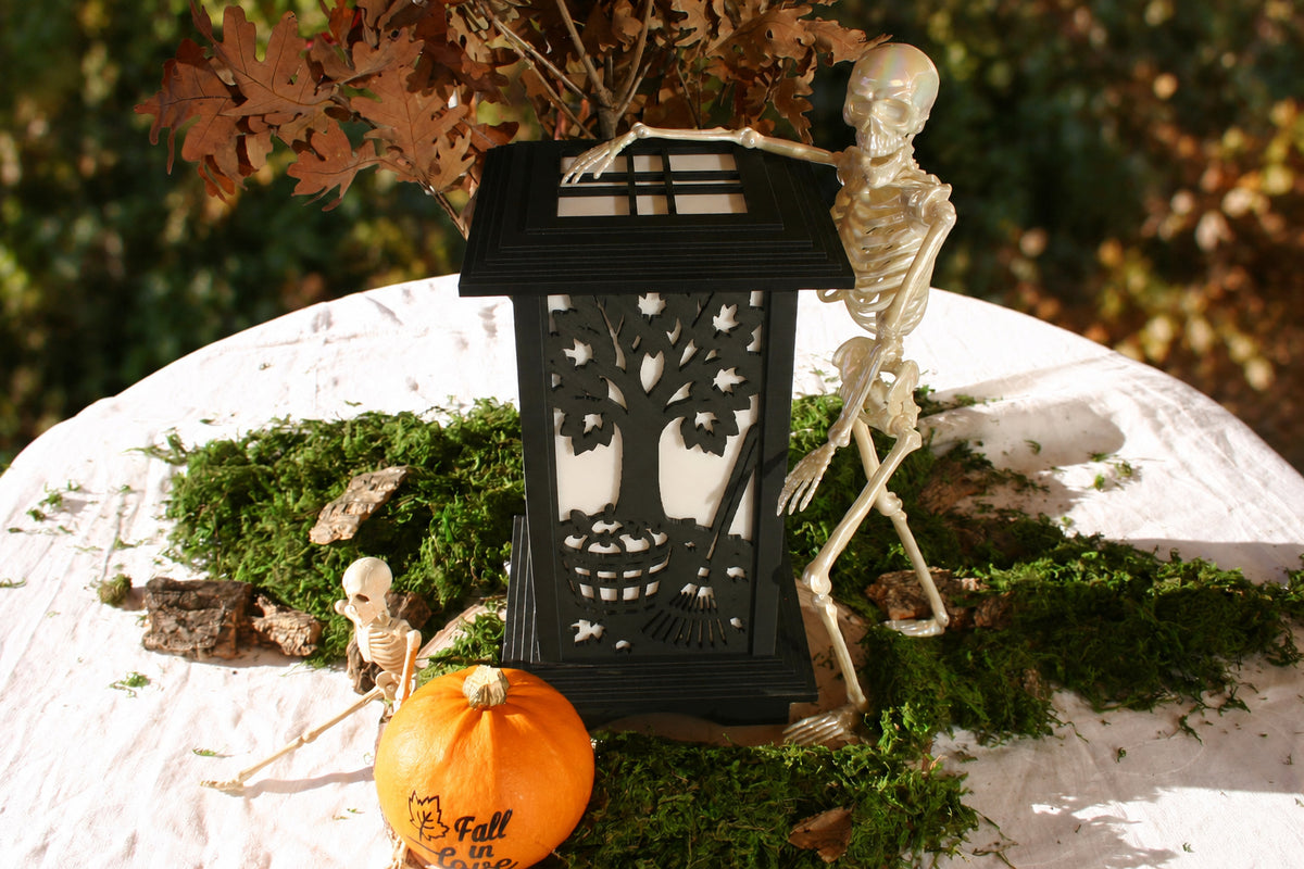 Kyoto lamp with Harvest Tree panel beside a skeleton and pumpkin in an autumn display