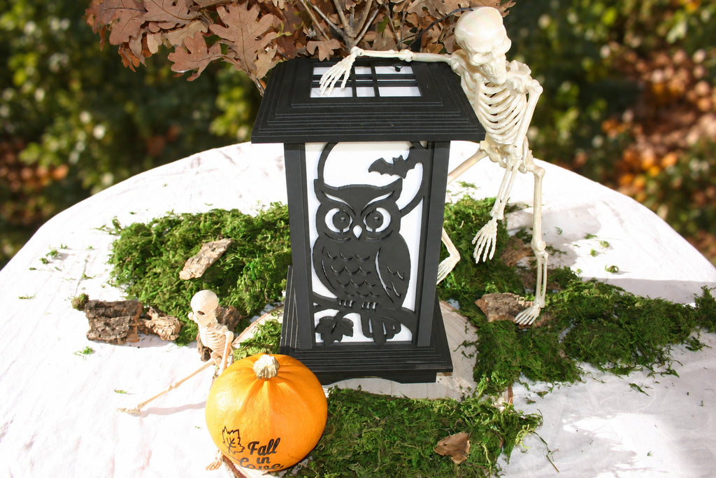 Kyoto lamp with Moonlit Owl & Bat panel beside a skeleton and pumpkin in an autumn display