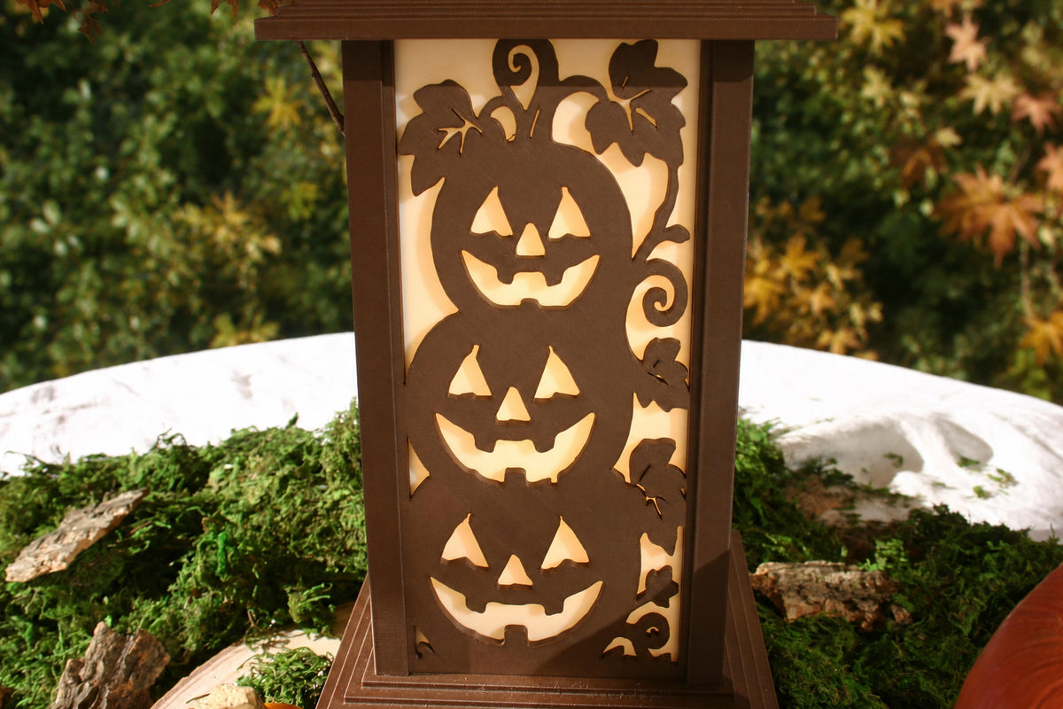 Three stacked jack-o'-lantern silhouettes and curling vines on a Kyoto lamp panel