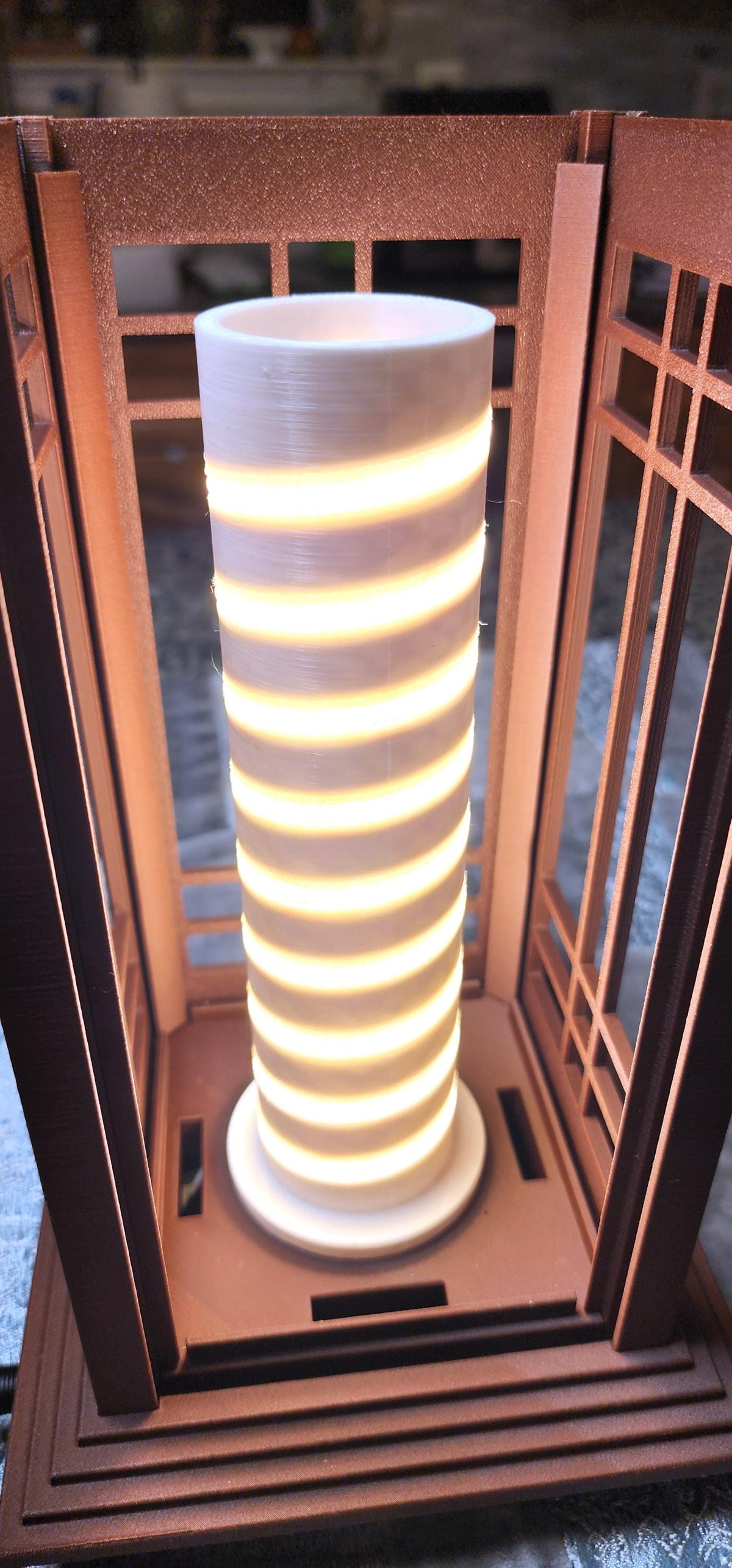 Close-up of the illuminated LED lighting core inside a Prairie Beacon Table Lantern by Promenade Lighting. With the exterior diffusers removed, the photograph reveals a cylindrical white core with a continuous spiral of warm white LED lighting securely seated in a purpose-built channel, rather than relying on adhesive alone. The integrated lighting assembly sits within the lantern's American-inspired geometric frame, demonstrating the thoughtful engineering behind every complete Prairie Beacon lantern.