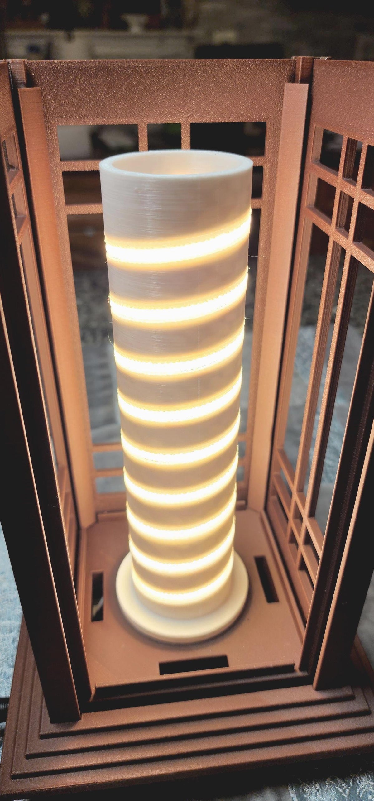 Close-up of the illuminated LED lighting core inside a Prairie Beacon Table Lantern by Promenade Lighting. With the exterior diffusers removed, the photograph reveals a cylindrical white core with a continuous spiral of warm white LED lighting securely seated in a purpose-built channel, rather than relying on adhesive alone. The integrated lighting assembly sits within the lantern's American-inspired geometric frame, demonstrating the thoughtful engineering behind every complete Prairie Beacon lantern.