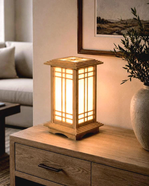 The Prairie Beacon table lantern pairs an inviting wood-tone finish with the sculptural elegance of American-inspired architecture. Slender corner posts, intricate geometric latticework, and translucent panels rise from a square base to a gracefully overhanging roof. Thoughtfully designed and 3D printed, its layered details create a distinctive statement piece, bringing warmth, character, and architectural beauty to a bedside table, bookshelf, or favorite corner.