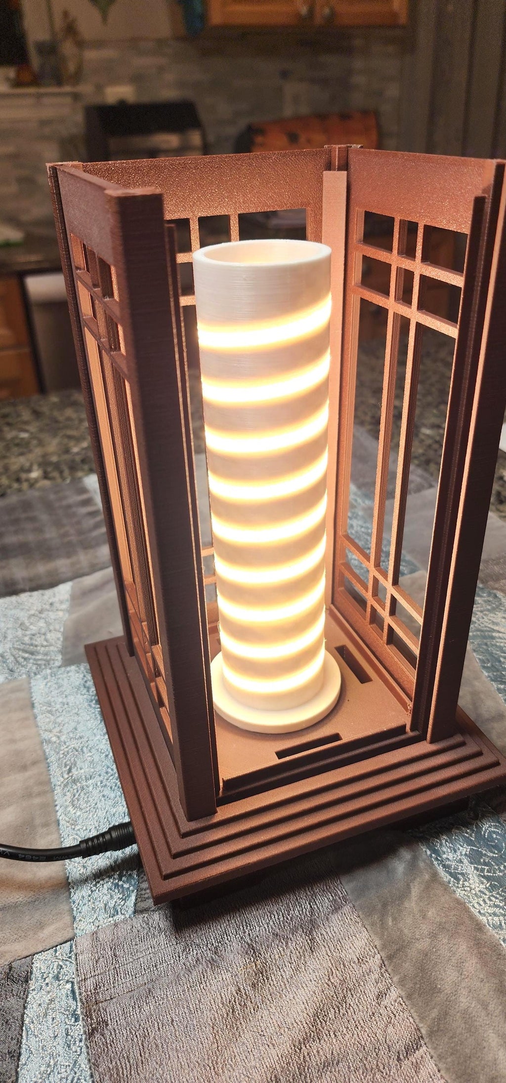 Close-up of the illuminated LED lighting core inside a Prairie Beacon Table Lantern by Promenade Lighting. With the exterior diffusers removed, the photograph reveals a cylindrical white core with a continuous spiral of warm white LED lighting securely seated in a purpose-built channel, rather than relying on adhesive alone. The integrated lighting assembly sits within the lantern's American-inspired geometric frame, demonstrating the thoughtful engineering behind every complete Prairie Beacon lantern.