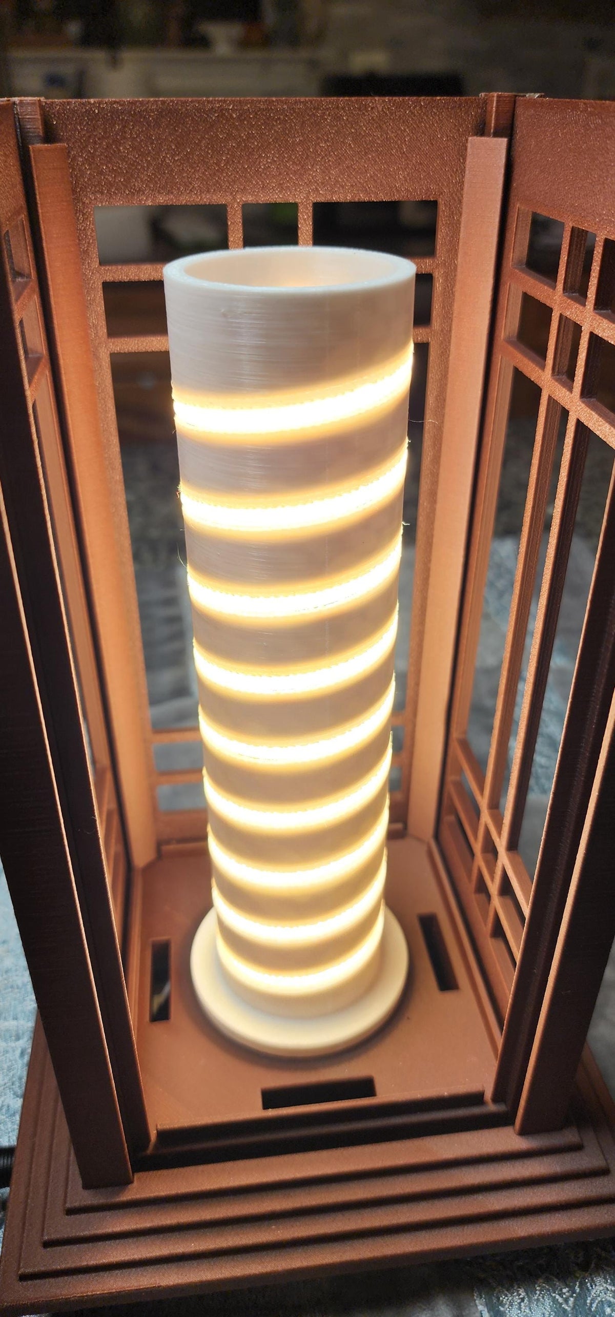 Close-up of the illuminated LED lighting core inside a Prairie Beacon Table Lantern by Promenade Lighting. With the exterior diffusers removed, the photograph reveals a cylindrical white core with a continuous spiral of warm white LED lighting securely seated in a purpose-built channel, rather than relying on adhesive alone. The integrated lighting assembly sits within the lantern's American-inspired geometric frame, demonstrating the thoughtful engineering behind every complete Prairie Beacon lantern.